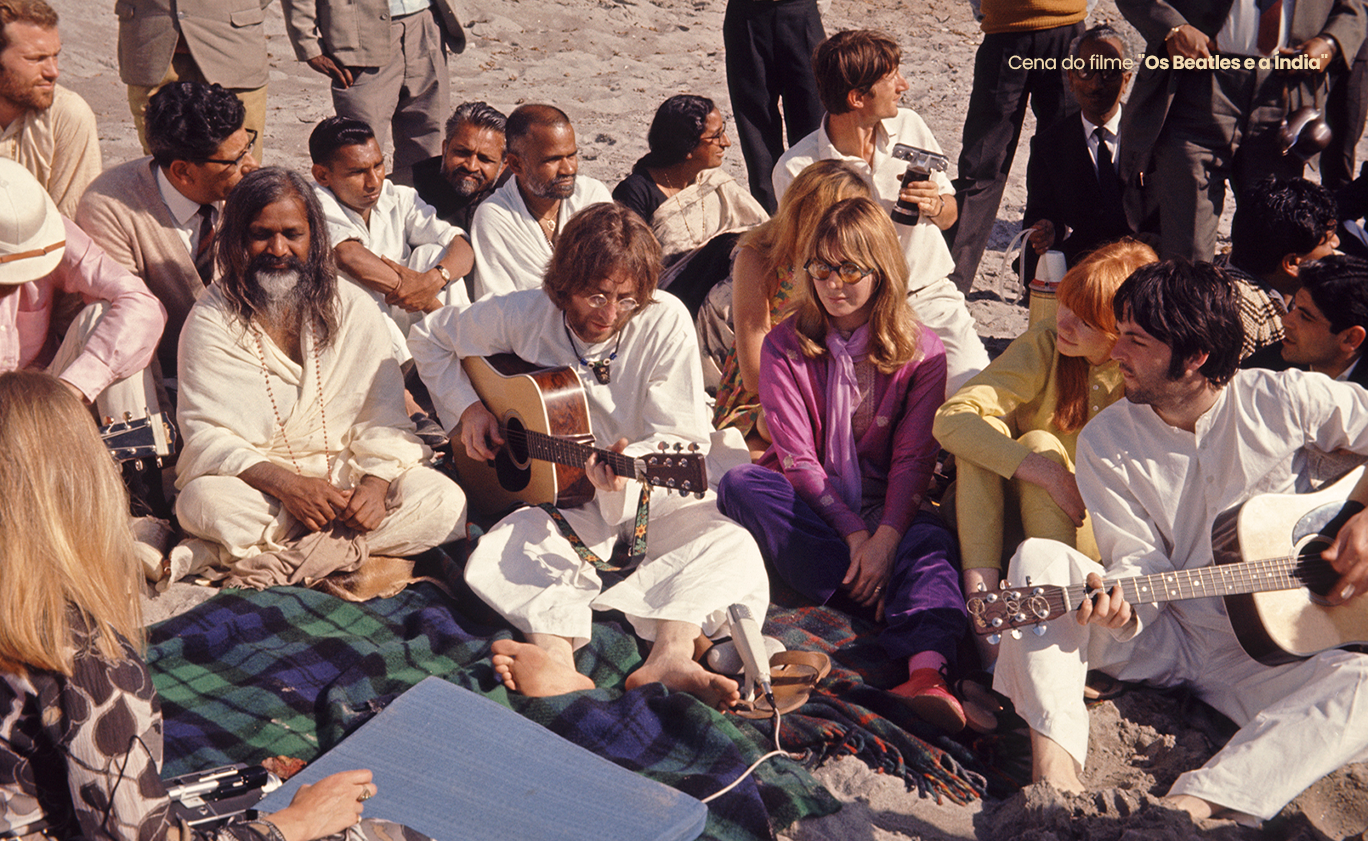 Maharishi Mahesh Yogi, John Lennon, Paul McCartney e o grupo reunidos com violões na Índia